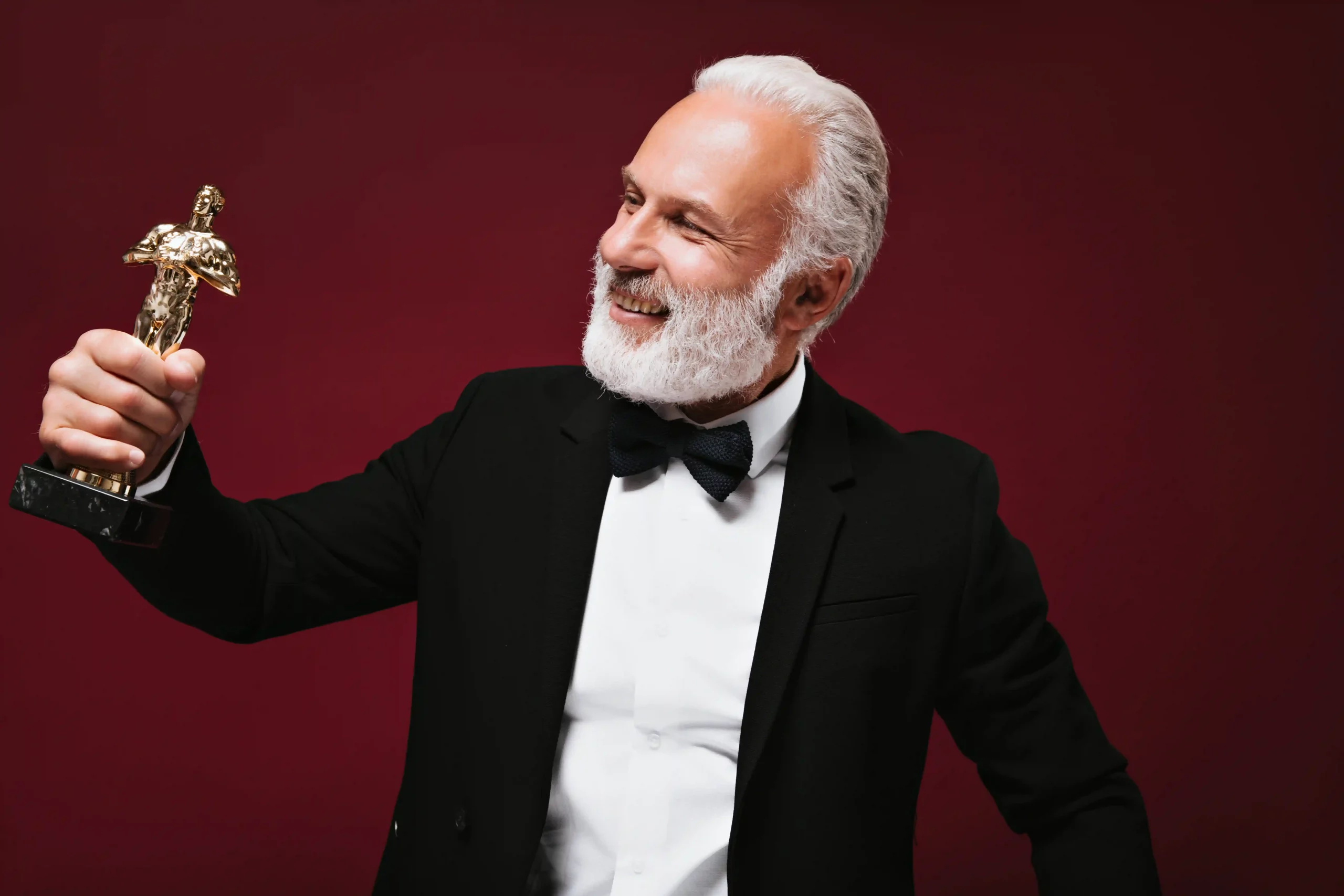 happy-man-white-shirt-jacket-looks-oscar-statuette