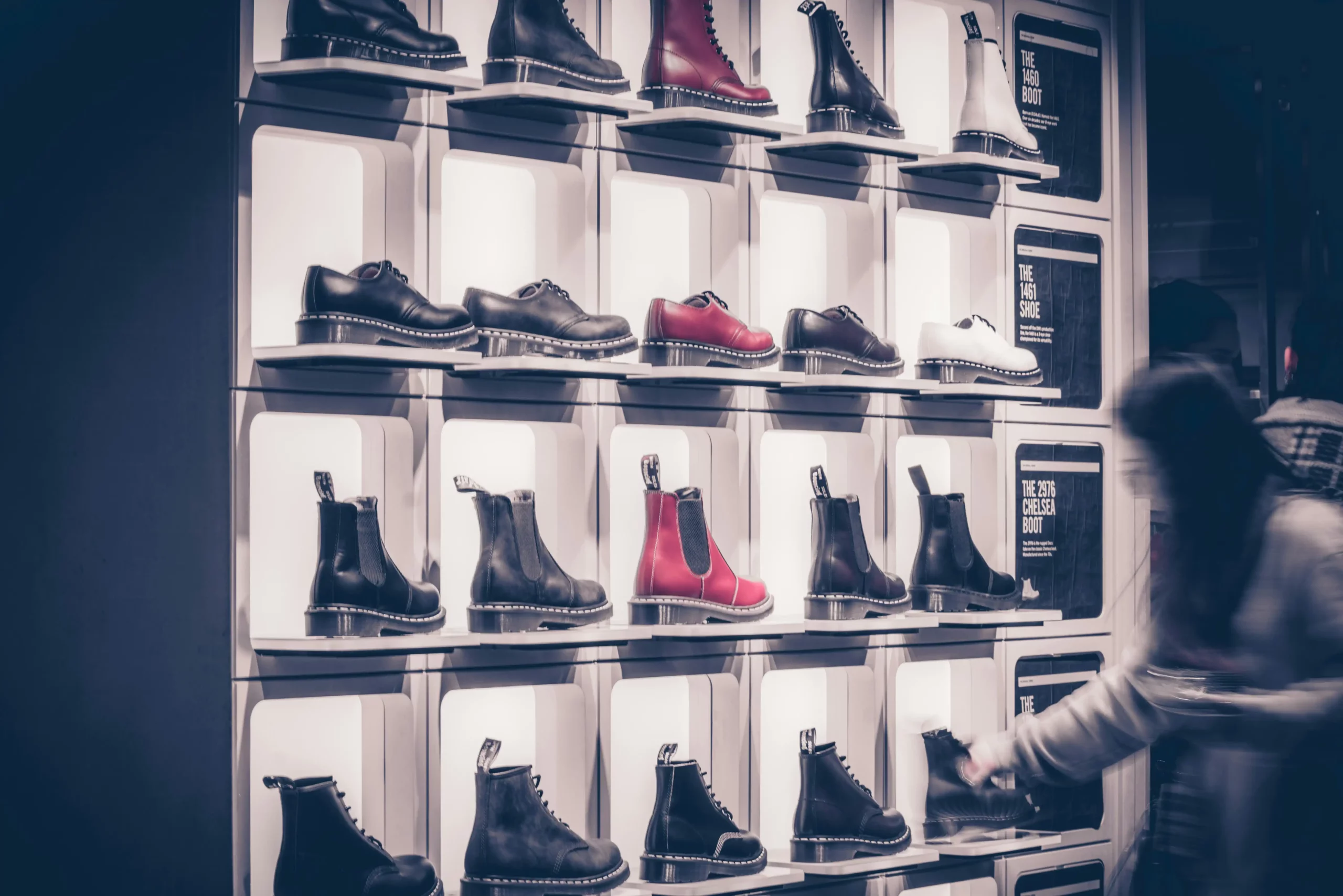 a woman standing in front of a display of shoes